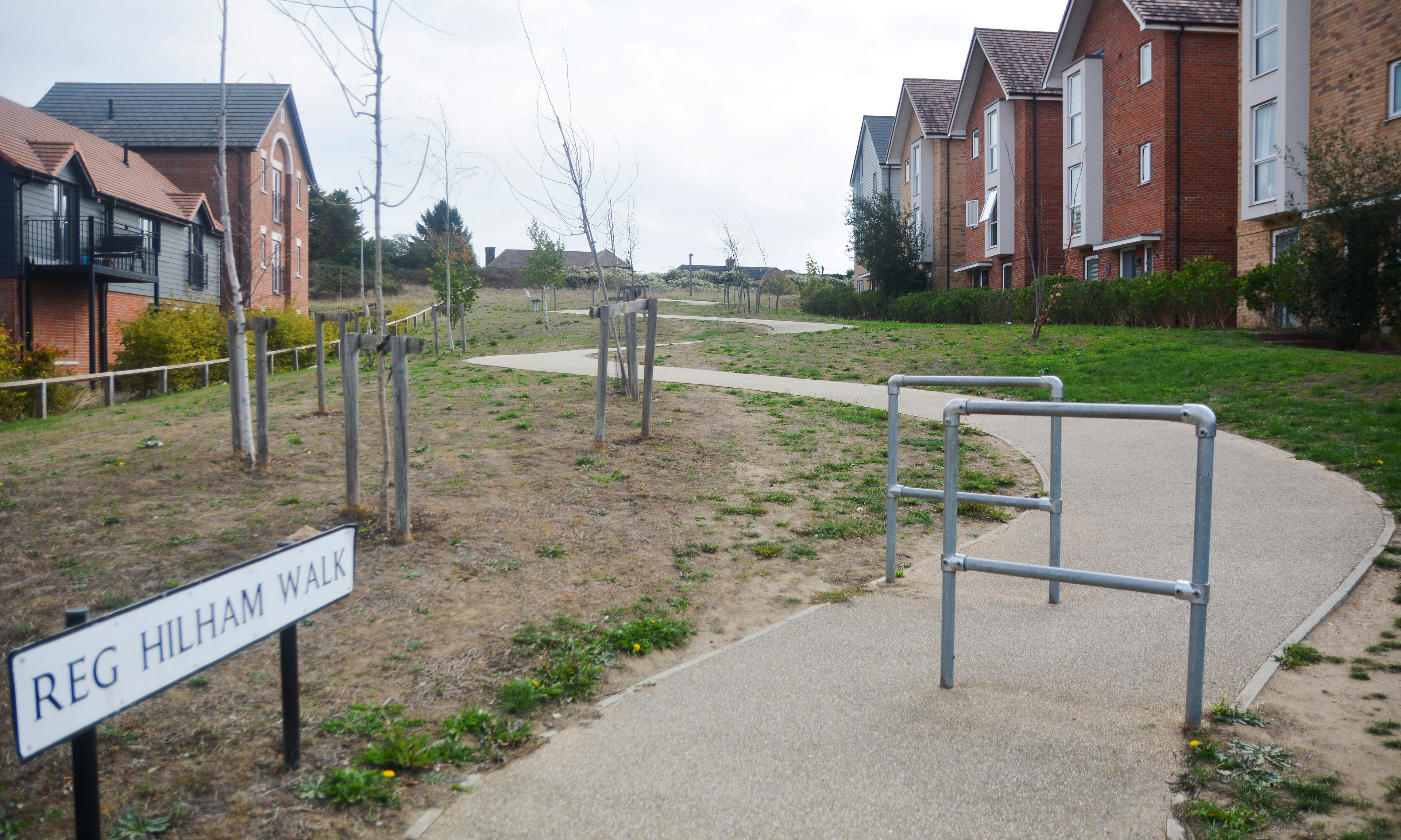 Neglected new build estate with bare earth and overgrown areas